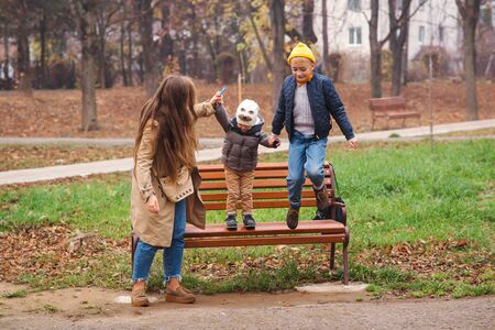 Happy family in autumn on the nature. Mother and her sons having fun outdoors. Autumn holidays. Young family walk in autumn park.の写真素材