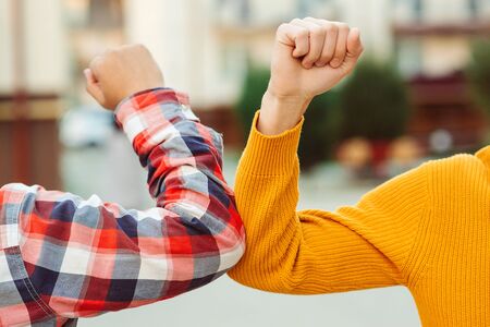 Friends bump elbows outdoors. Coronavirus epidemic. Health care concept. Social distancing. Elbow bump. New greeting style. Coronavirus quarantine. Fight coronavirus.の写真素材