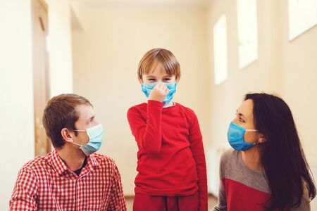 Family wearing face masks. Prevention coronavirus. Stay at home. Home quarantine. Coronavirus epidemic. Parents and kid wearing a surgical masks. Coronavirus outbreak. New real life.の写真素材