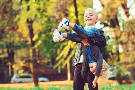 Cute children having fun together in autumn park. Happy brothers walking in nature. Autumn family weekend. Happy family on a walk. Two boys playing in autumn leaves. Happy and healthy childhood.の写真素材