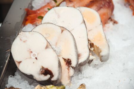 Fish market, showcase with seafood. Butterfish steak, close up. Retail sale, marketplace. Fresh fish fillets of salmon, butterfish and tuna. Healthy seafood concept.の写真素材
