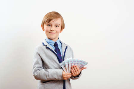 Little businessman holding money. Money for future education. Financial literacy of children. Winner, lottery and millionaire. Finance business investment. Money saving. Cute boy showing fan of money.の写真素材