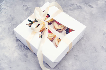 Gift box with tasty cupcakes. Present box full of fruit cupcakes. Birthday party. Easter or...