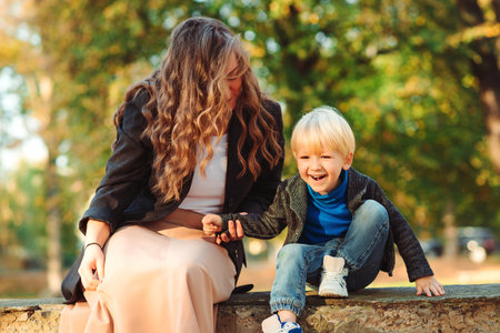 Mother spending time with little son. Happy young family on autumn walk. Mom and little son enjoying...