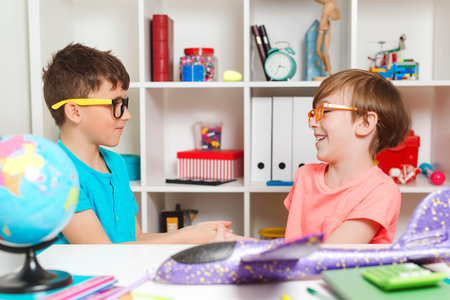 Happy classmates doing handshake. Back to school concept. Boys doing homework together. Happy...