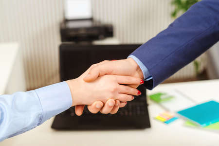 Business people shaking hands in the office. Finishing successful meeting. Handshake closeup of businesswoman and businessman. Handshake business partners.の写真素材
