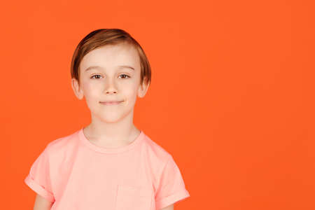 Cute handsome smiling preteen boy posing at studio. Portrait of a cheerful young boy. Child dressed in casual colorful tshirt, being in good mood. Beauty, summer, fashion.の写真素材