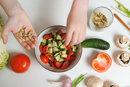 Seeds mix for salad. Young chef cooking healthy vegetable salad at the kitchen, top view. Son preparing healthy food for family dinner. Healthy eating and diet concept.の写真素材