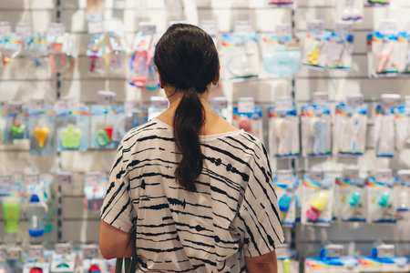 Pregnant woman shopping in baby store. Woman choosing baby stuff at baby shop store. Mom is choosing newborn baby product in the supermarket. Pregnancy and shopping.の写真素材