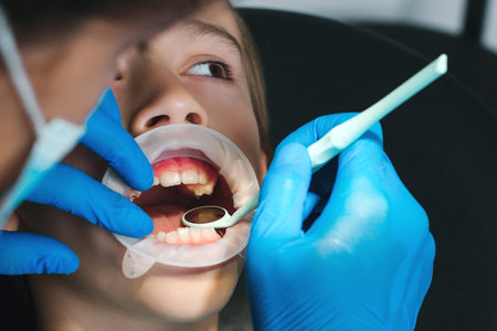 Boy patient visiting specialist in dental clinic. Dentist examining boy's teeth. Kid in clinic doing dental treatment. Dentist orthodontics. Afraid child on dental chair.の写真素材