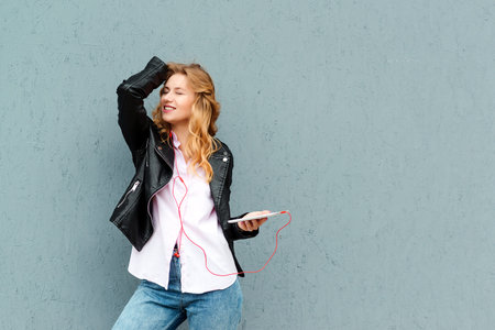Woman listening music with headphones and gadget. Girl dancing, enjoying freedom and music....