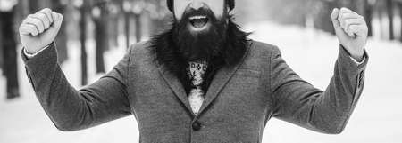 Successful bearded man in winter. Man winner happy outdoors. Young man wearing winter clothes in the street. Male winter fashion. Lifestyle, people and success.の写真素材