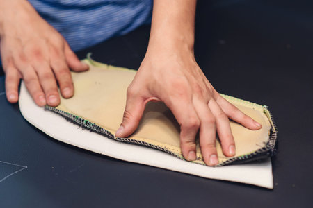 Leather worker workshop. Man holding crafting tool and working, close up. Making things handmade....