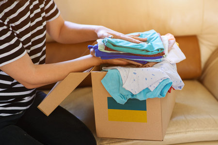 Volunteer cyrrying box with Humanitarian aid for Ukrainian refugees. Charity and Helping poor and...