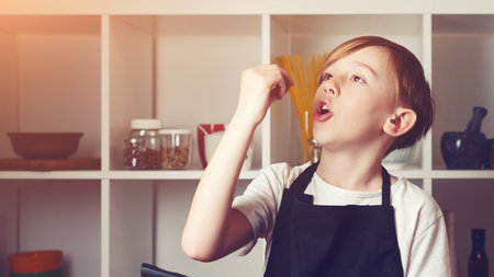 Chef trying a new recipe. Boy at cooking classes. child cooking. Cute little chef holding frying pan at kitchen. Funny boy wearing apron. future profession.の写真素材