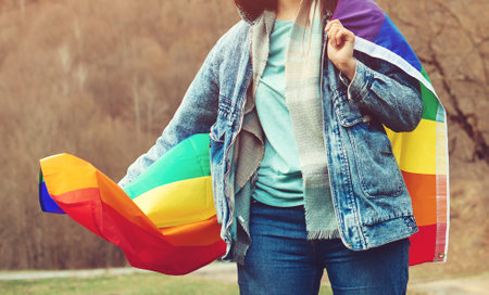 Happiness, freedom and love concept for same sex couples. Lifestyle, people and love. Celebrating the lgbt lesbian women rights. Woman holding the rainbow flag on the nature.の写真素材