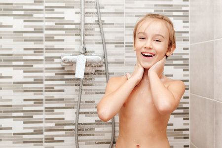 Cute child washing himself in shower. Happy boy having a shower in bathroom. Healthy childhood, lifestyle concept.の写真素材