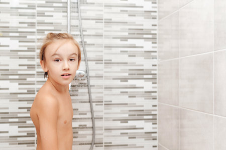 Cute child washing himself in shower. Happy boy having a shower in bathroom. Healthy childhood, lifestyle concept.の写真素材