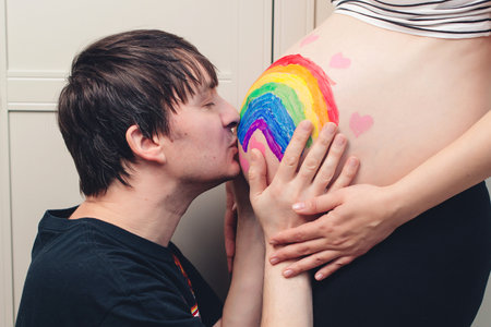 Husband kissing newborn through wife belly. Future dad kissing belly of his pregnant wife. Man kissing stomach, pregnant woman, love. Marriage, support and pregnancy, mother, father with baby in bellyの写真素材