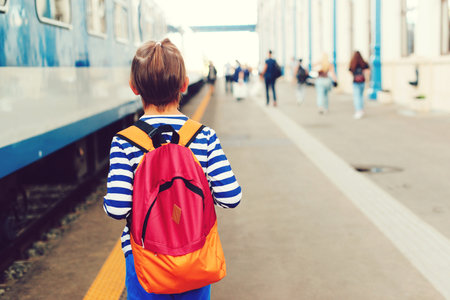 Boy waiting for express train on railway station platform. Kid with backpack on a subway. Travel, tourism, vacation and family concept.の写真素材