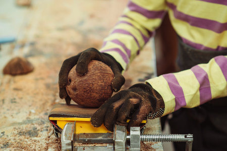 Young carpenter working in craft workshop. Creative student doing his project in workshop. Boy in the workshop makes crafts with coconut. School, development and learning concept.の写真素材