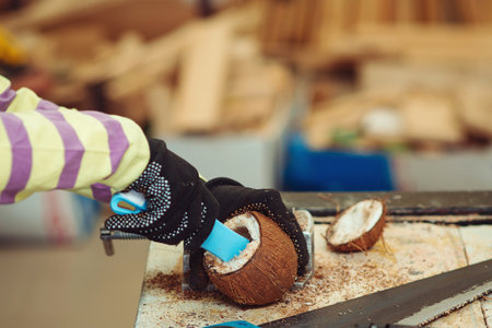 Young carpenter working in craft workshop. Creative student doing his project in workshop. Boy in the workshop makes crafts with coconut. School, development and learning concept.の写真素材