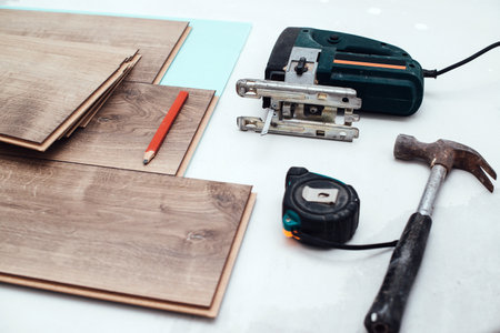 Wooden laminate top view. Repair of a floor covering. Abstract laminate background. Floor installation. Wood laminate and tools. Floor background texture. Woodenの写真素材
