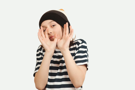 Excited boy having fun and posing at studio. Portrait of eleven years old boy. Boy wearing stylish woolen hat and tshirt. Lifestyle, people, emotion concept.の写真素材