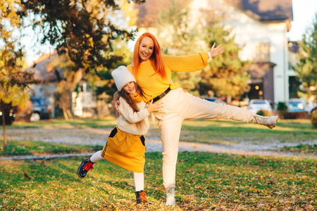 Happy family enjoying autumn day. Family autumn walk. Autumn holidays, lifestyle, childhood. Mother and child girl having fun together.の写真素材