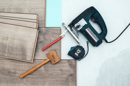 Floor installation. Wood laminate and tools. Floor background texture. Wooden laminate top view. Repair of a floor covering. Abstract laminate background.の写真素材