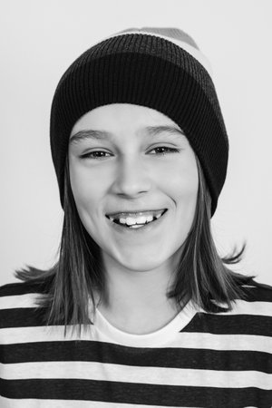 Happy boy wearing stylish woolen hat. Kid posing over on white background. Face portrait of eleven years old boy. Excited guy looking at camera and smiling.の写真素材