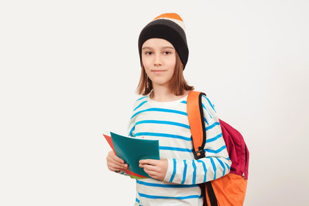 School boy with backpack holding books. Education concept. Cute teenager with school backpack. Back to school. Boy in casual clothes with books for studying.の写真素材