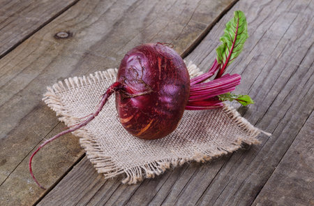 Single organic beetroot over rustic wooden background