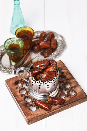 Traditional Ramadan food: dates and tea over white wooden backgroundの写真素材