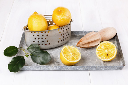 Group of organic lemon in a vintage metal colander on white wooden background の写真素材