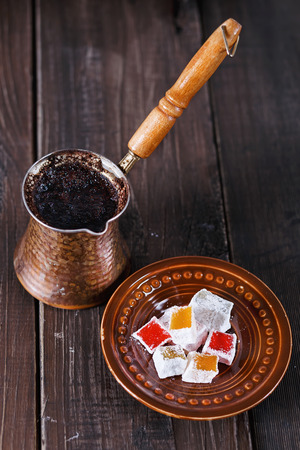 Turkish coffee and Turkish Delight over dark wooden background. Selective focusの写真素材