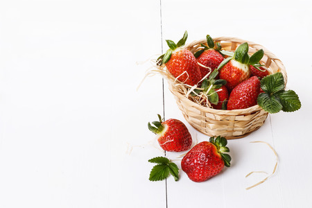 Fresh strawberries in a woven basket on a white backgroundの写真素材
