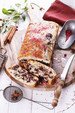 Sliced cranberry loaf on a wooden tray over white wooden backgroundの写真素材