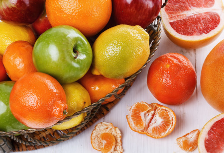 Colorful fruits in a basket over white wooden backgroundの写真素材