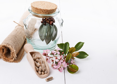 Herbal medicine pills and hawthorn over white backgroundの写真素材