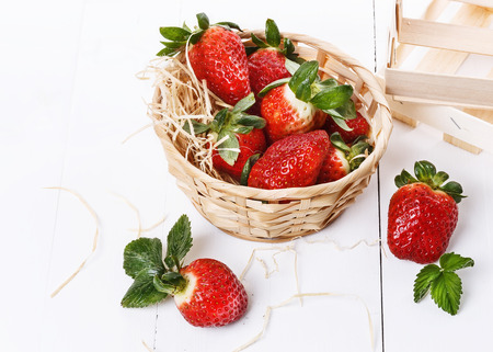 Fresh strawberries in a woven basket on a white backgroundの写真素材