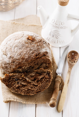 Freshly baked rye sourdough cob loaf and olive oil on wooden background.の写真素材