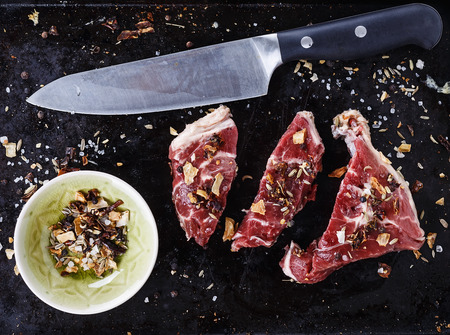 Red meat, spices and knife over rustic metal background. Top viewの写真素材
