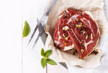 Red meat and fork over white wooden background with copy spaceの写真素材