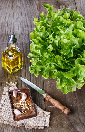 Green Oakleaf Lettuce , oil and spices over rustic wooden background. Selective focusの写真素材