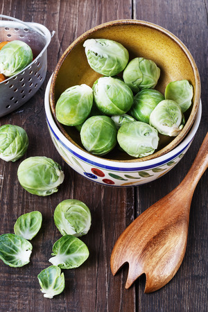 Brussels sprouts in a ceramic bowl over rustic wooden background. Selective focusの写真素材