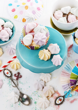 Colorful meringue drops and party decor over white wooden background. Selective focusの写真素材