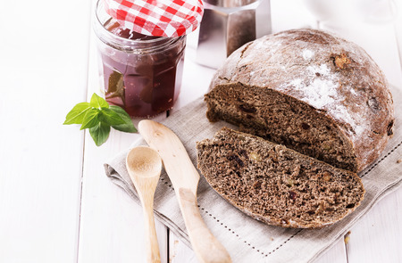 Rye sourdough bread with nuts and dry fruits on white wooden background. Selective focus, shallow depth of field, Copy spaceの写真素材