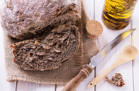 Freshly baked rye sourdough with walnuts and pears on white wooden background close up. Selective focusの写真素材