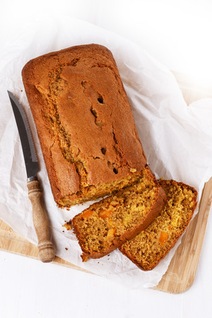 Pumpkin bread loaf and vintage knife over white wooden background. Top viewの写真素材